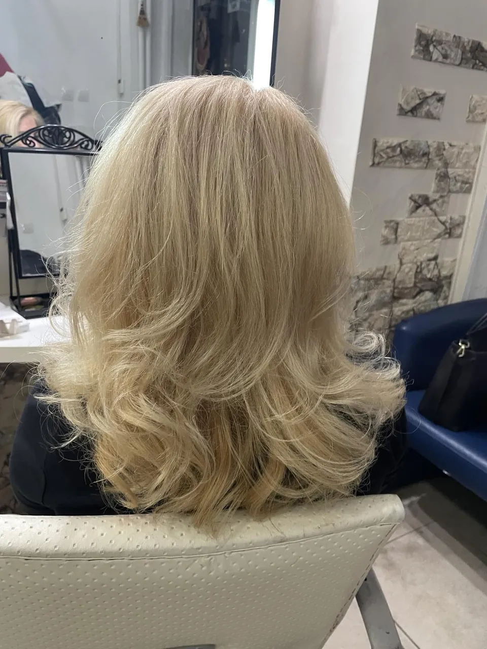 Златисто руса коса на пластове и меки вълни, гледана в гръб